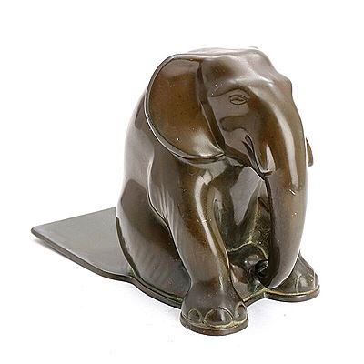 Just Andersen : A patinated “disko” metal book end cast with a sitting elephant.